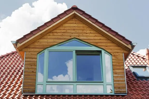 Individuell geformte Fensteranlage mit Schrägen in einem hölzernen Giebel