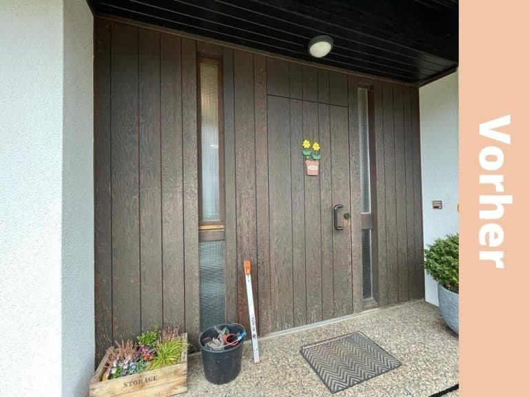 Dunkler Hauseingang mit alter Holztür vor der Sanierung