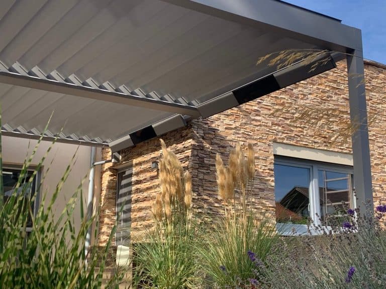 Geöffnete Aluminiumlamellen über einer Terrasse