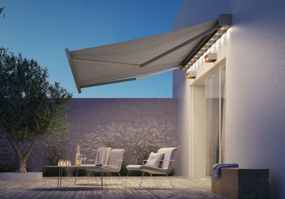 Kassettenmarkise mit integrierter LED-Beleuchtung über einer Terrasse am Abend