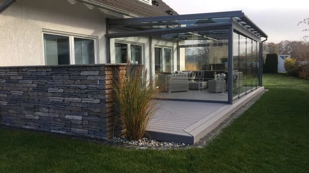 Großes Aluminium-Glasdach mit seitlichen Glasschiebewänden an einem Wohnhaus