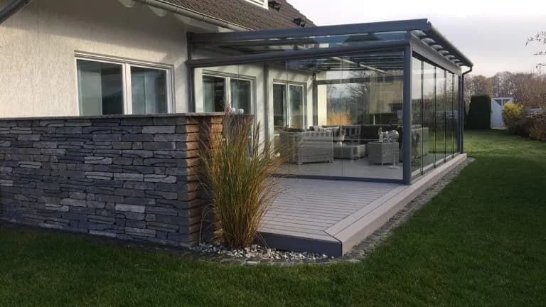 Gepflegtes Aluminium-Terrassendach mit Glasflächen und seitlichen Glasschiebewänden