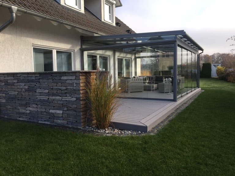 Aluminium-Terrassendach mit Glasdach und umlaufenden Glasschiebeanlagen an einem Wohnhaus